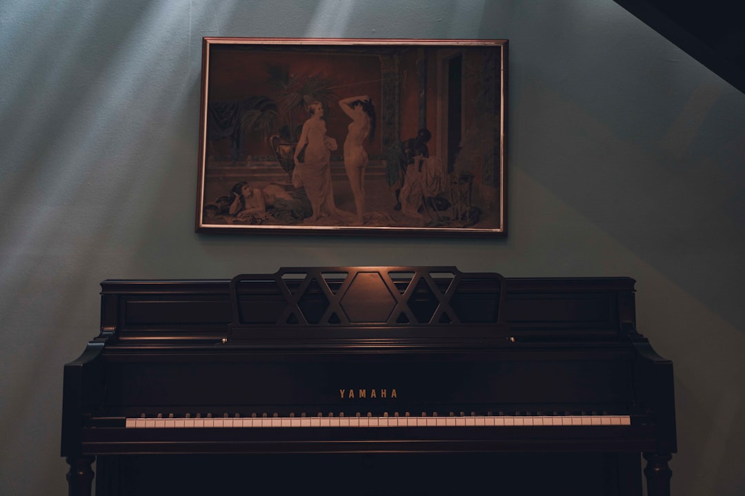 a piano in a room with a painting on the wall